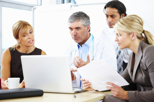 Healthcare professionals discussing a laptop