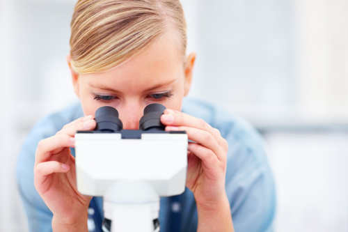 Woman looking into microscope